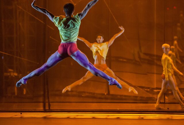 Alvaro Dule executes a grand leap in second position. His back facing the audience while his front is projected to the audience